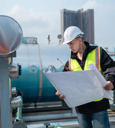 Engineer reviewing electrical and instrumentation drawings at an industrial facility